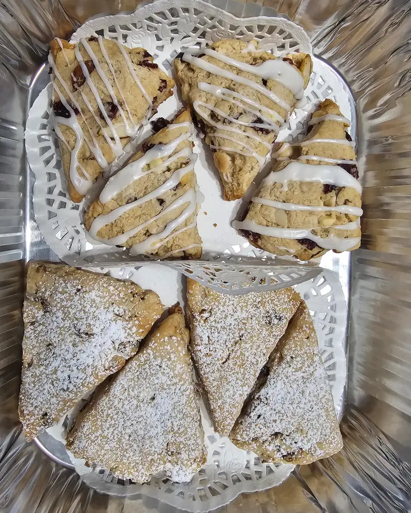 Glazed cranberry scones and sugar-dusted scones on a doily
